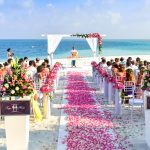 A seaside wedding with a rose walkway